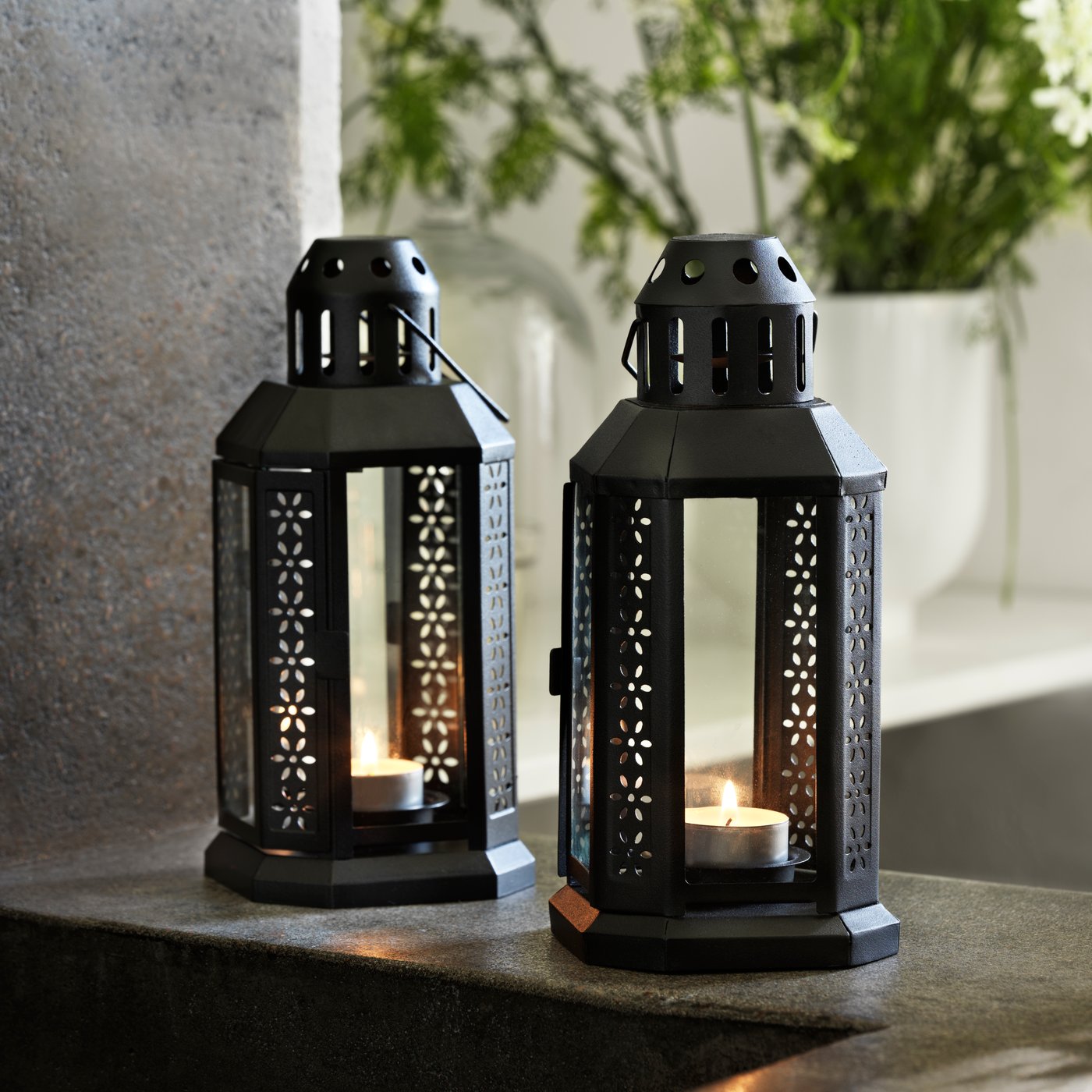 A black ENRUM lantern for tealight, in/outdoor outside