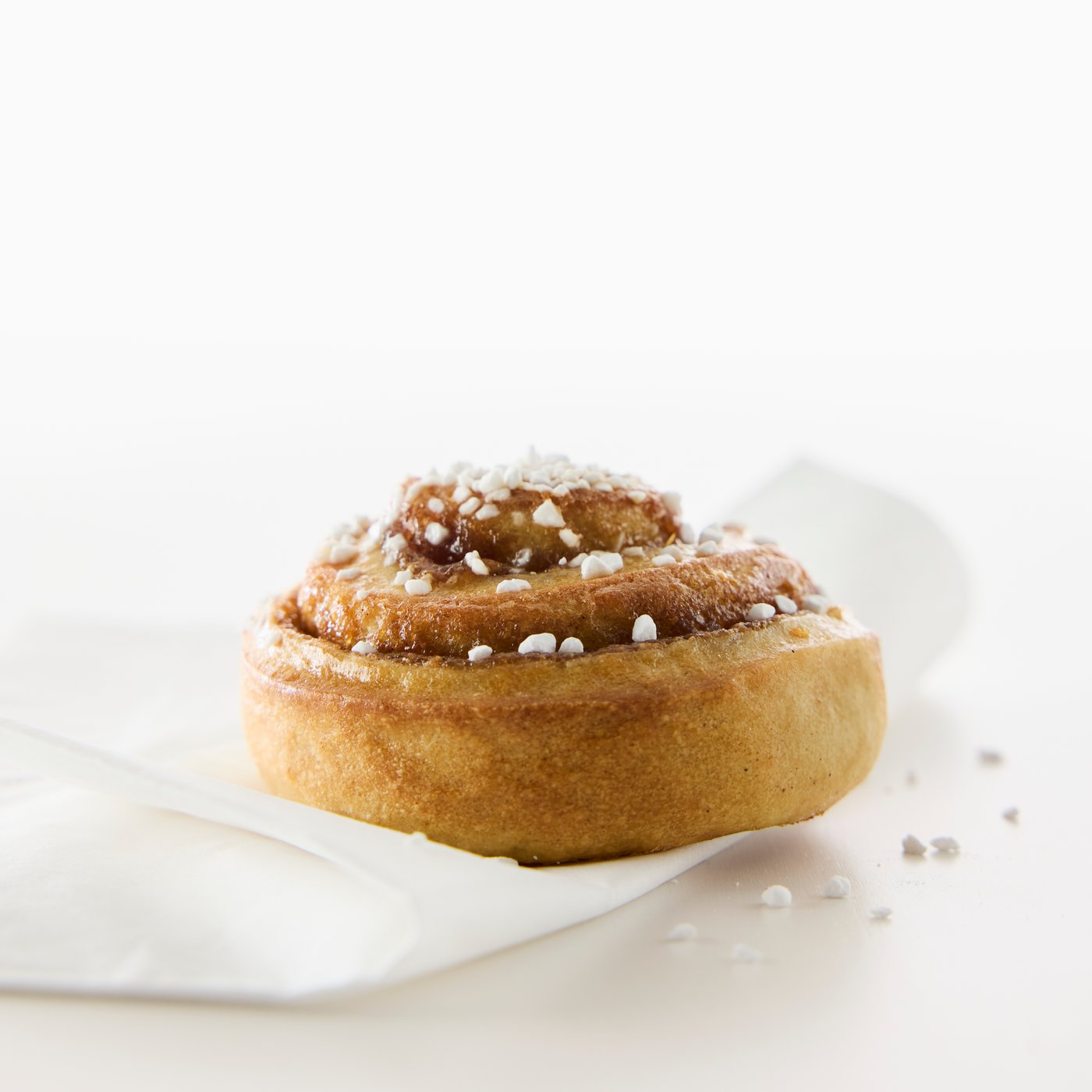Närbild av en läcker kanelbulle med pärlsocker.