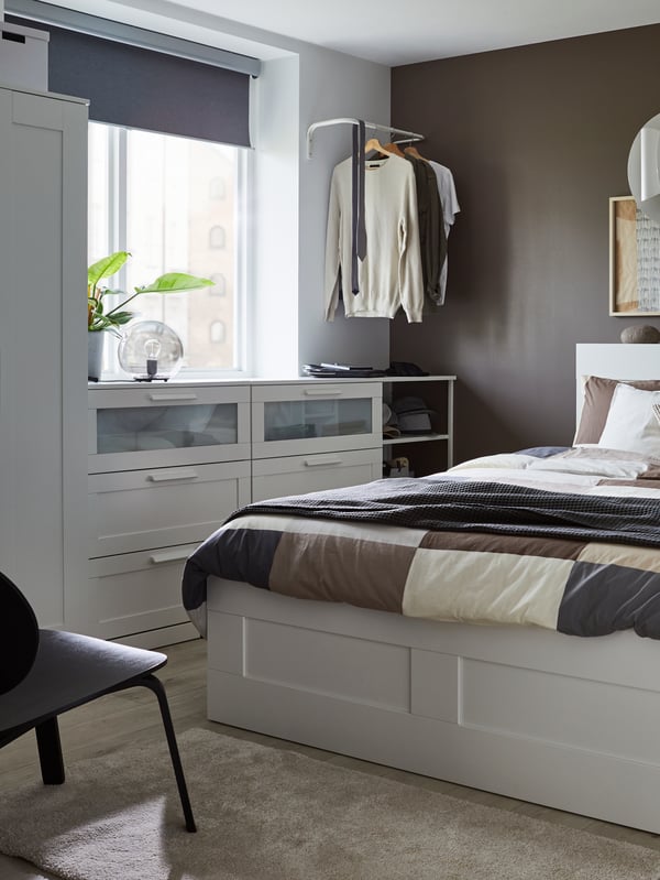BRIMNES krevet s odlaganjem i uzglavljem stoji u spavaćoj sobi nasuprot dve BRIMNES komode s 3 fioke i BRIMNES garderobera.