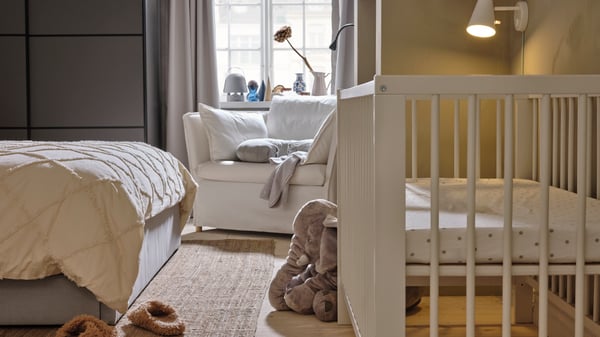 Un dormitorio matrimonial con una cuna IKEA.