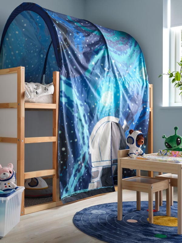 High wooden children's bed with a space-themed hood