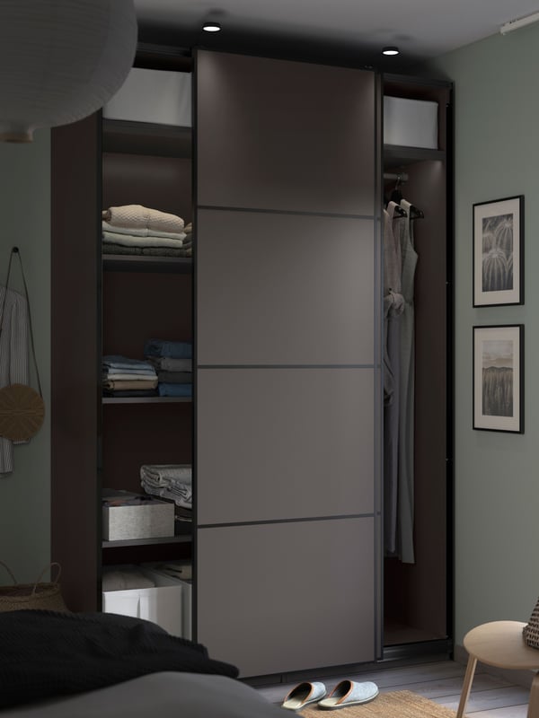PAX wardrobe complete with dark grey MEHAMN panel sliding doors in narrow space.