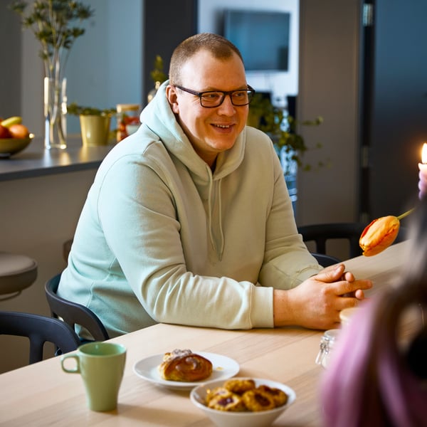 En man sitter och pratar med andra människor.