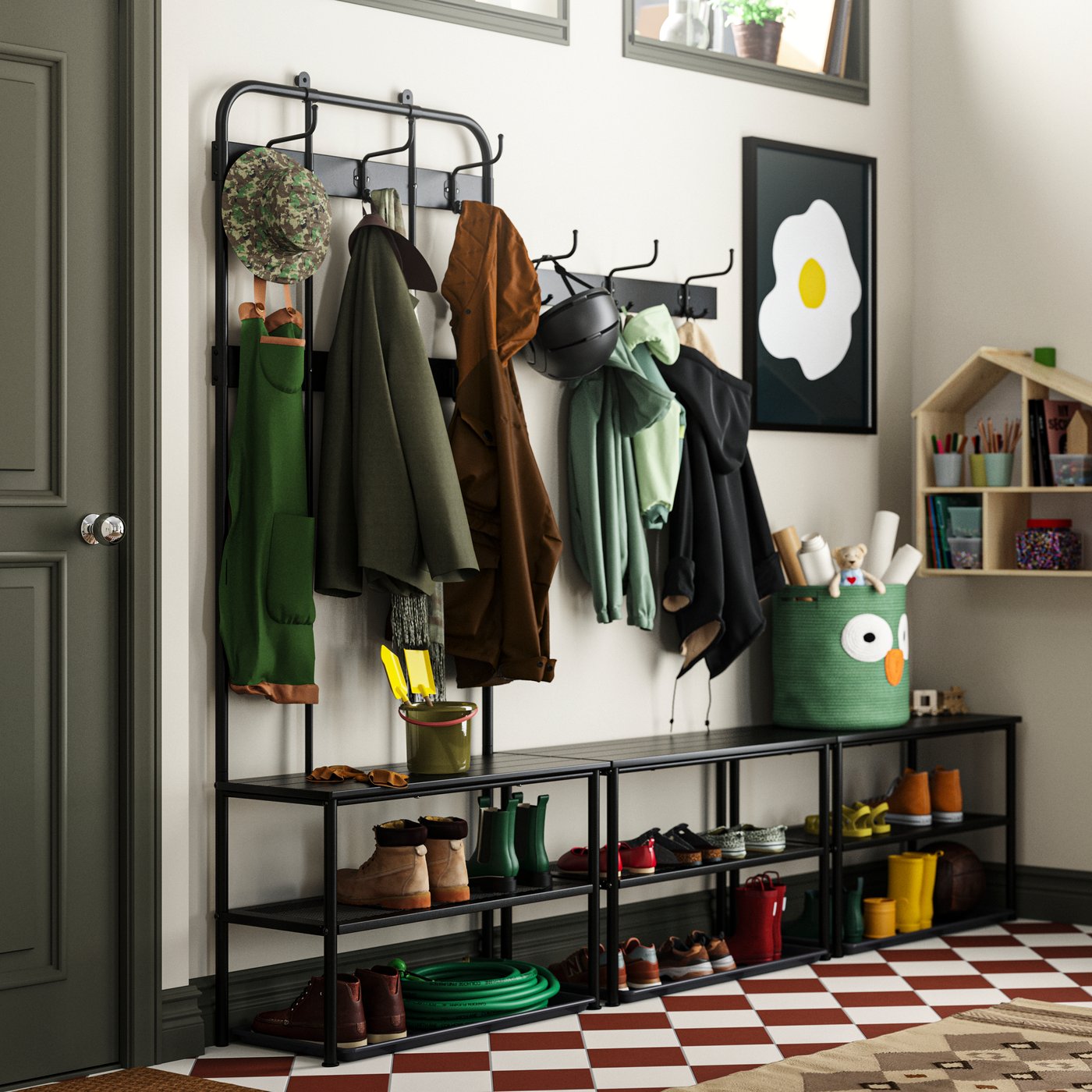 A big hallway with stairs leading up to a kitchen. NIPÅSEN coat rack and benches plus a work bench along the walls.
