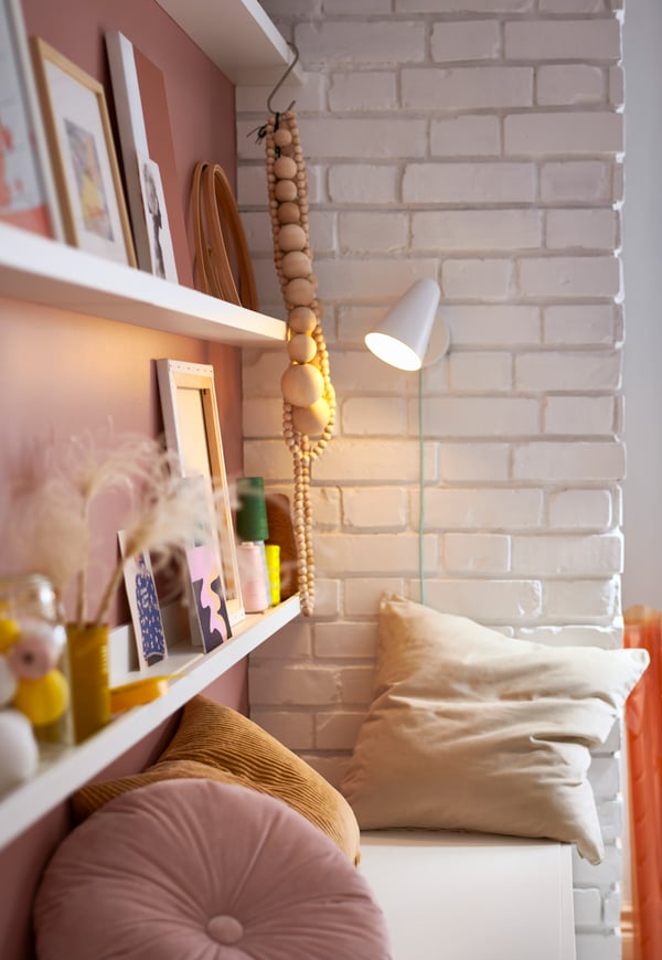 A bookshelf hung on the wall with various types of interior details on it.