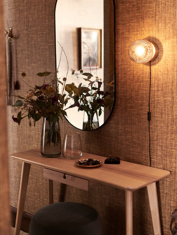 A retro SOLKLINT wall lamp in the hallway next to a LINDBYN mirror.