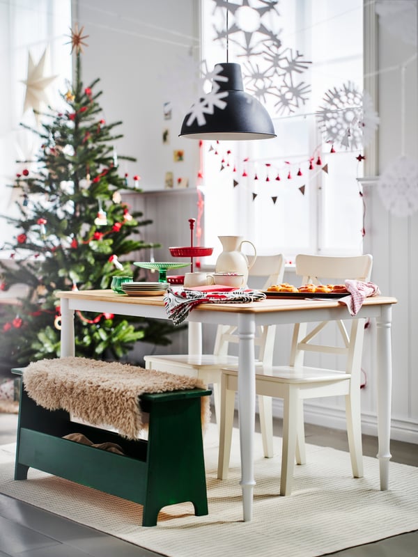 A DANDERYD dining table, two chairs and a PERJOHAN bench with storage in a bright dining room decorated for Christmas.