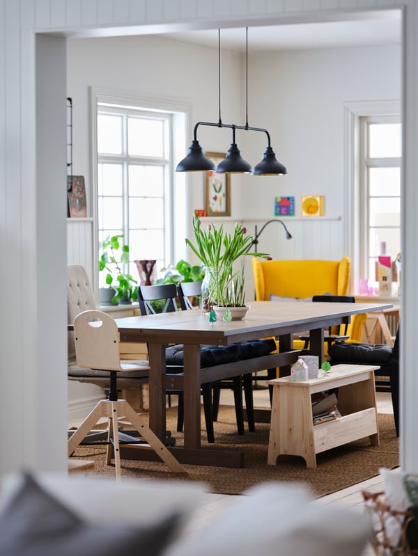 A wide, doorless opening connects a living room to a dining room with a grey-brown KLIMPFJÄLL dining table.
