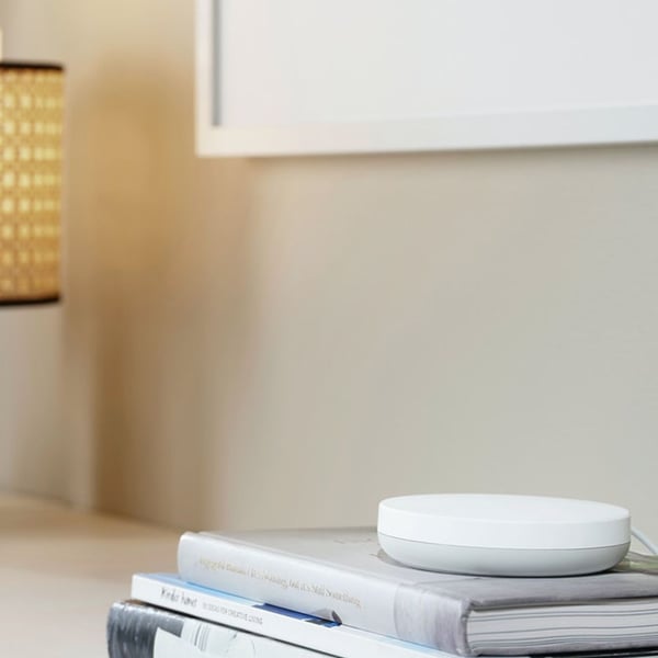 DIRIGERA-Hub für intelligente Produkte von IKEA auf einem Beistelltisch liegend.