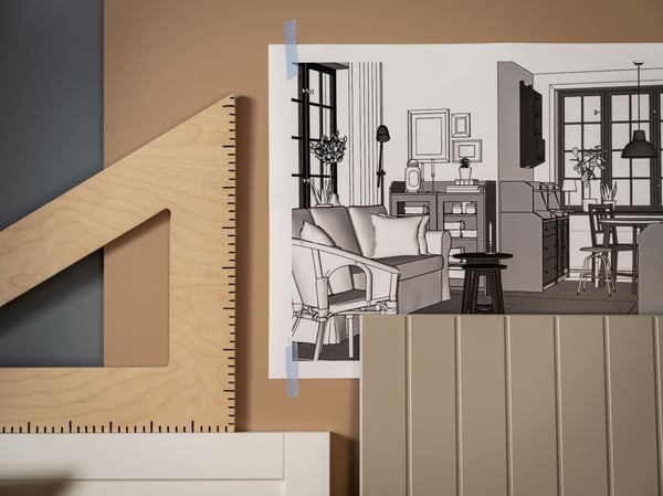 Office design plan hanging on a wall next to a wooden set square.