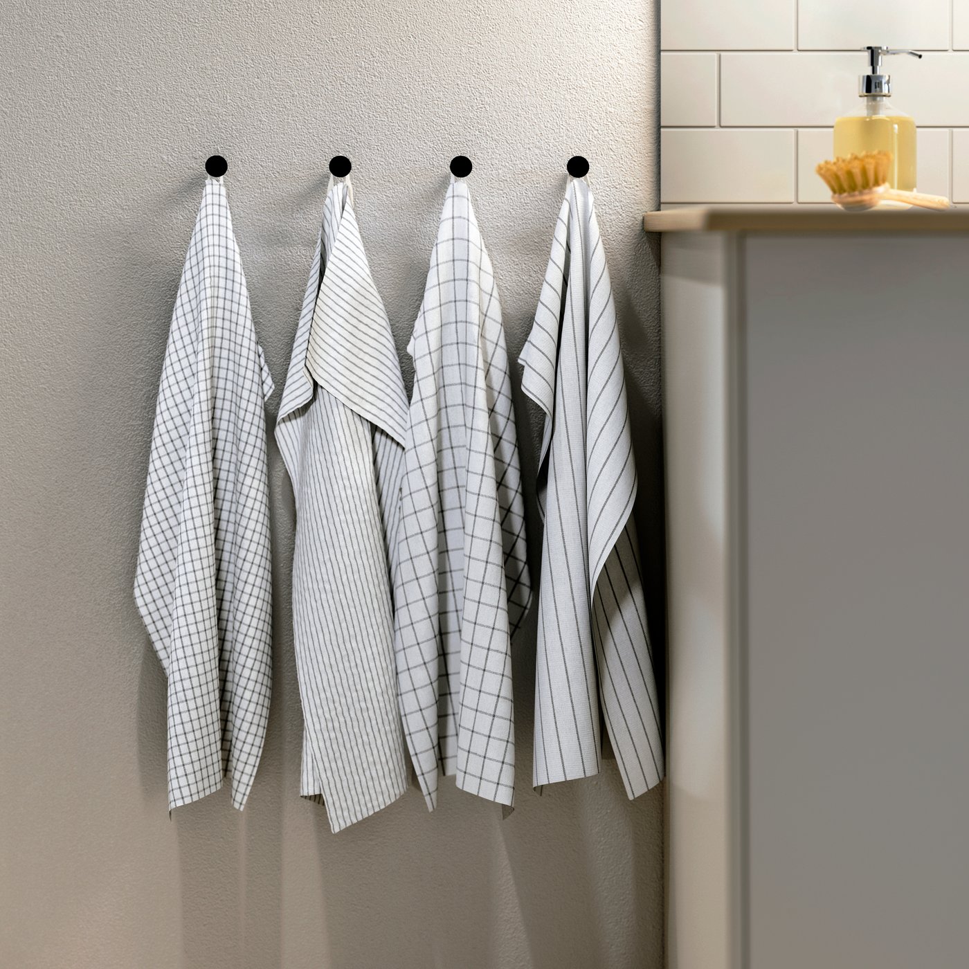 A white/dark grey/patterned RINNIG tea towel