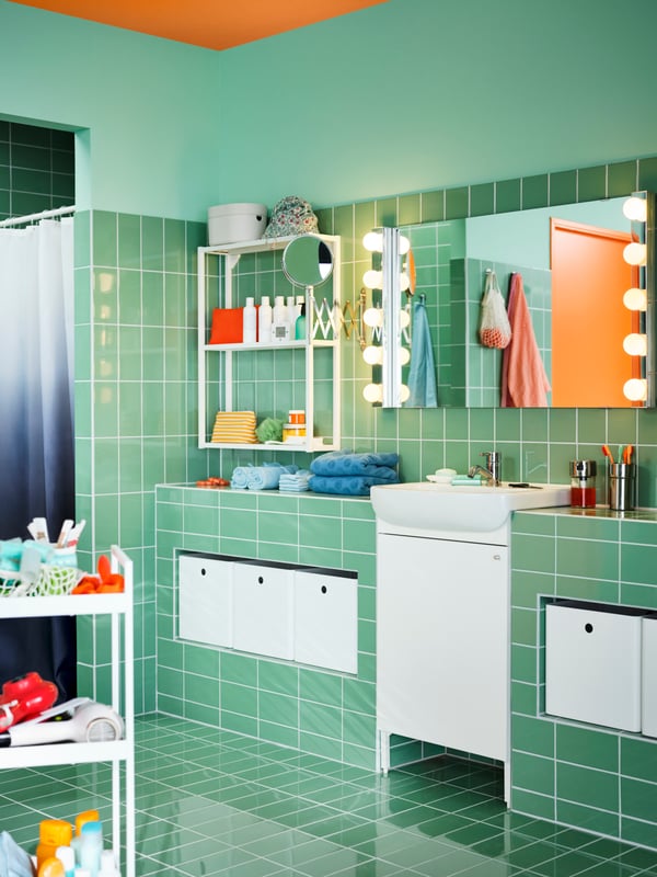 A bathroom with a rectangular LETTAN mirror with wall lamps above a white BJÖRKÅN sink and a white NYSJÖN wash basin cabinet.