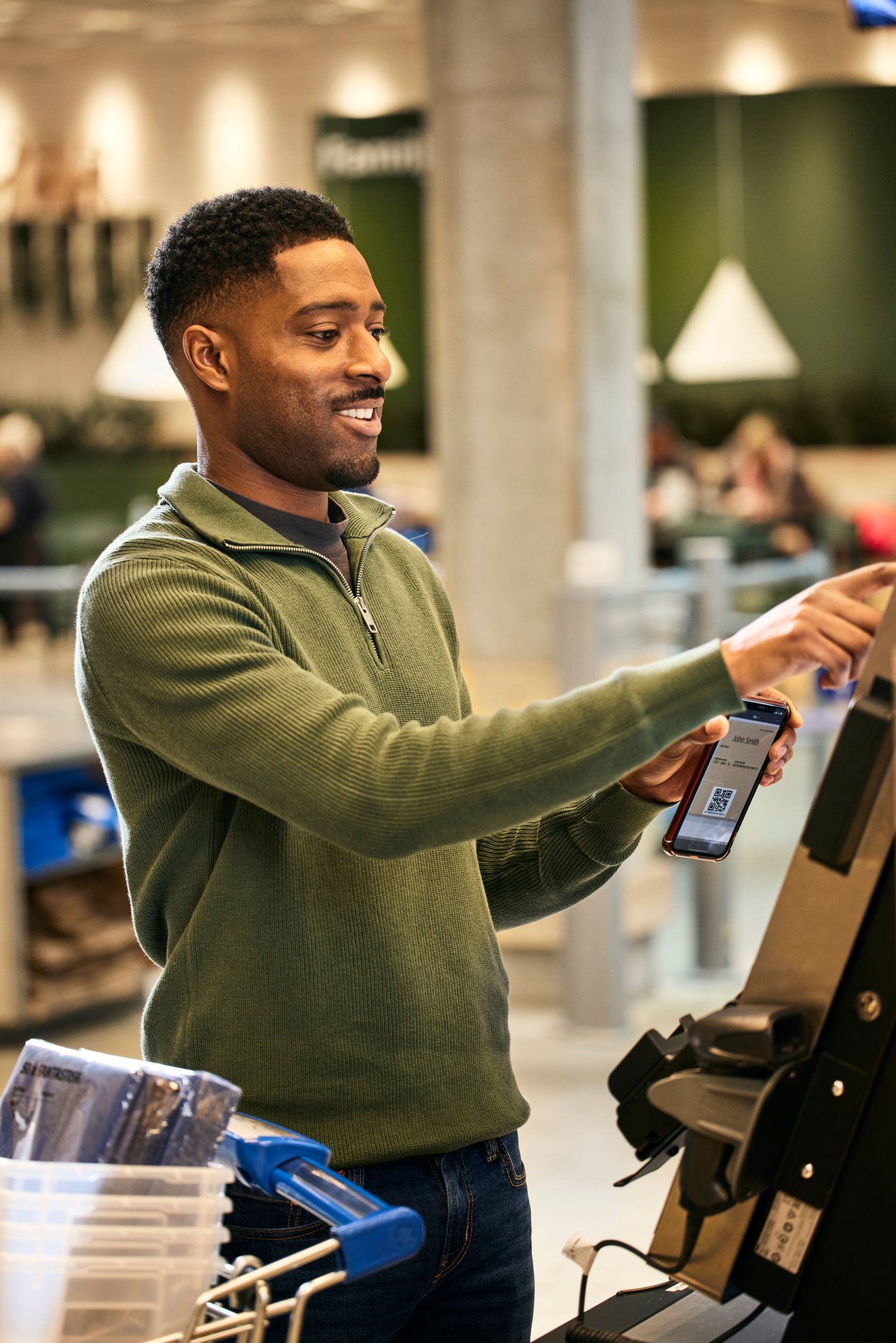 En kund i ett IKEA varuhus betalar med mobiltelefonen genom shop and go,