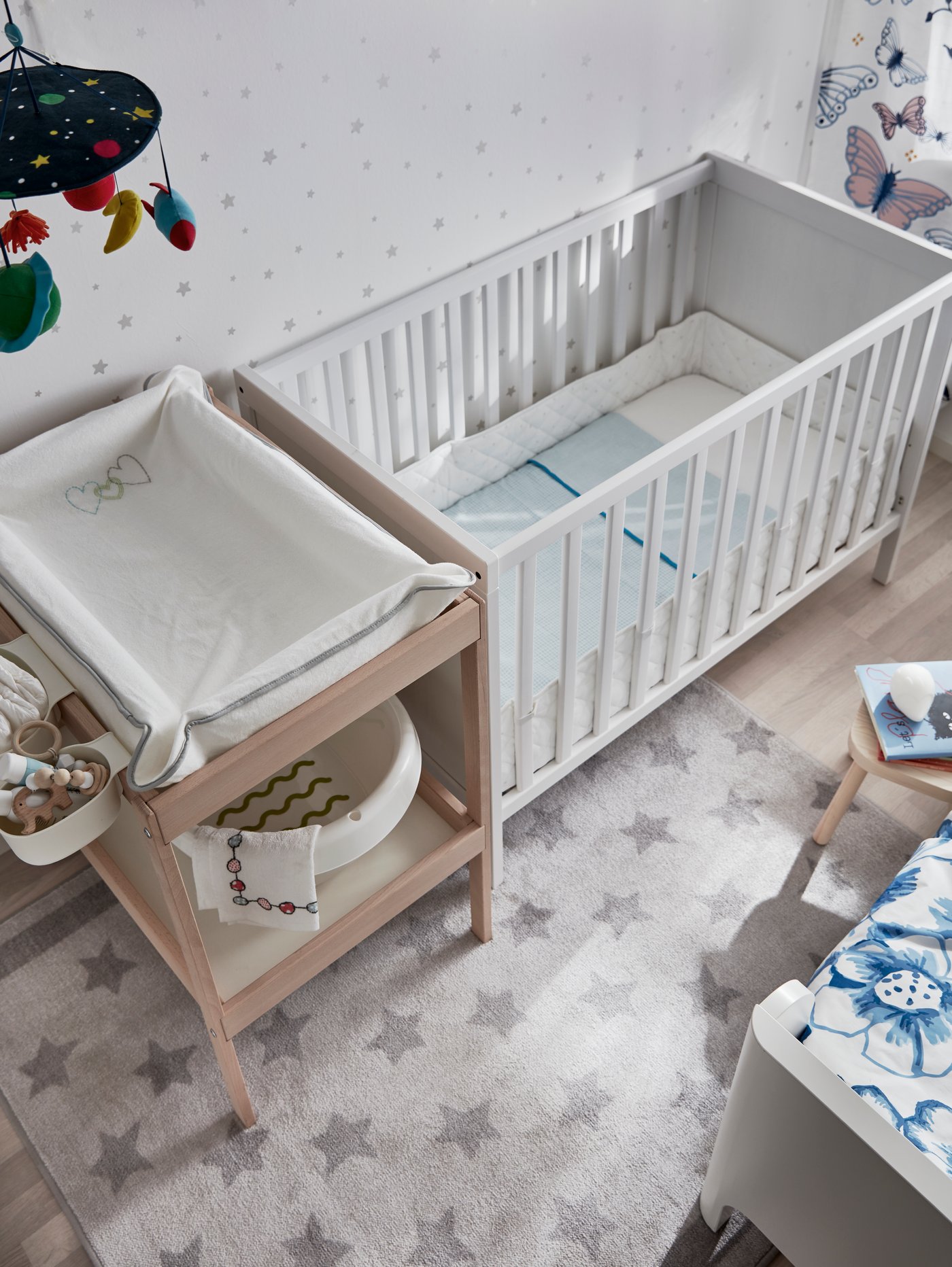 Ein weißes SUNDVIK Babybett und ein SNIGLAR Wickeltisch aus Jolz.