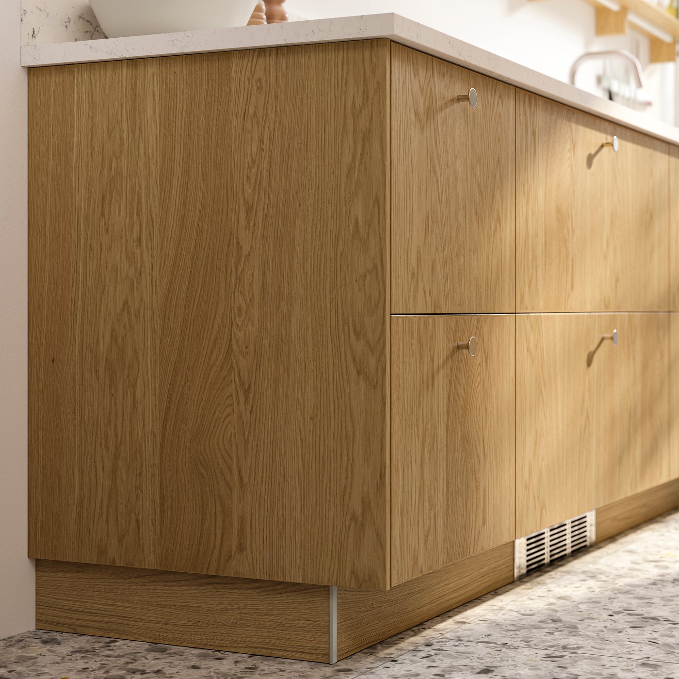 A closeup of SEKTION cabinets with fronts and cover panels in SINARP oak veneer and stainless steel-coloured KALERUM knobs.