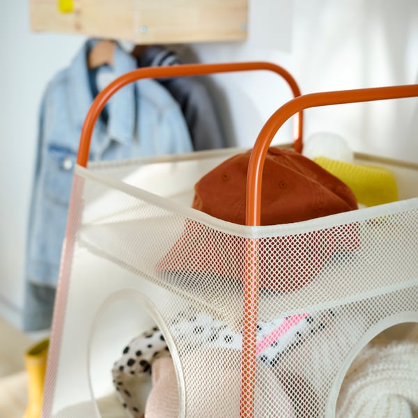Close-up of TIGERFINK storage with compartments in beige with orange details, full of caps and accessories.