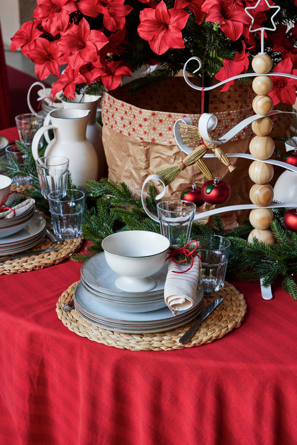 Table de Noël dressée de manière rustique avec de la vaisselle de table claire.
