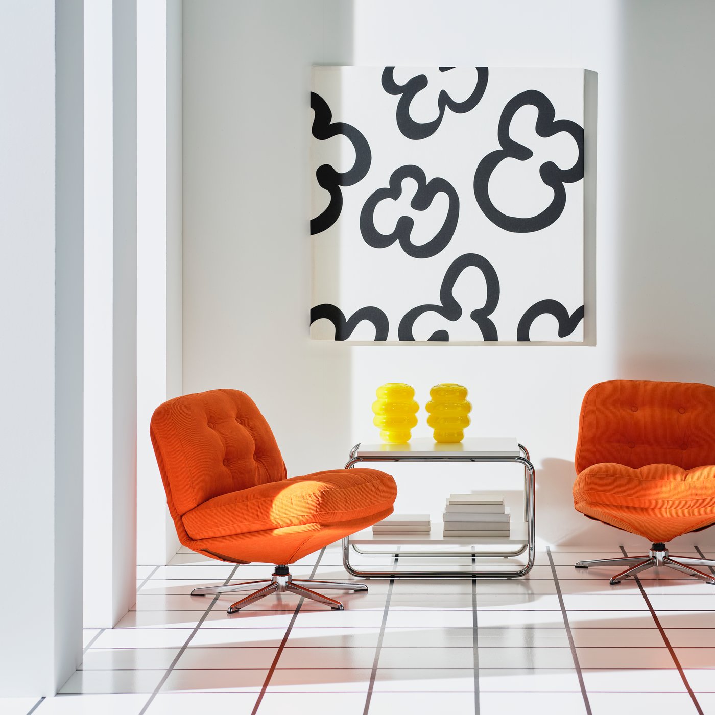 Two DYVLINGE armchairs are placed in front of a wall with a decoration made of black and white KLIPPBRÄCKA pre-cut fabric.