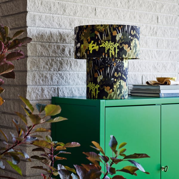 A green STOCKHOLM 2025 cabinet with 2 doors in the living room