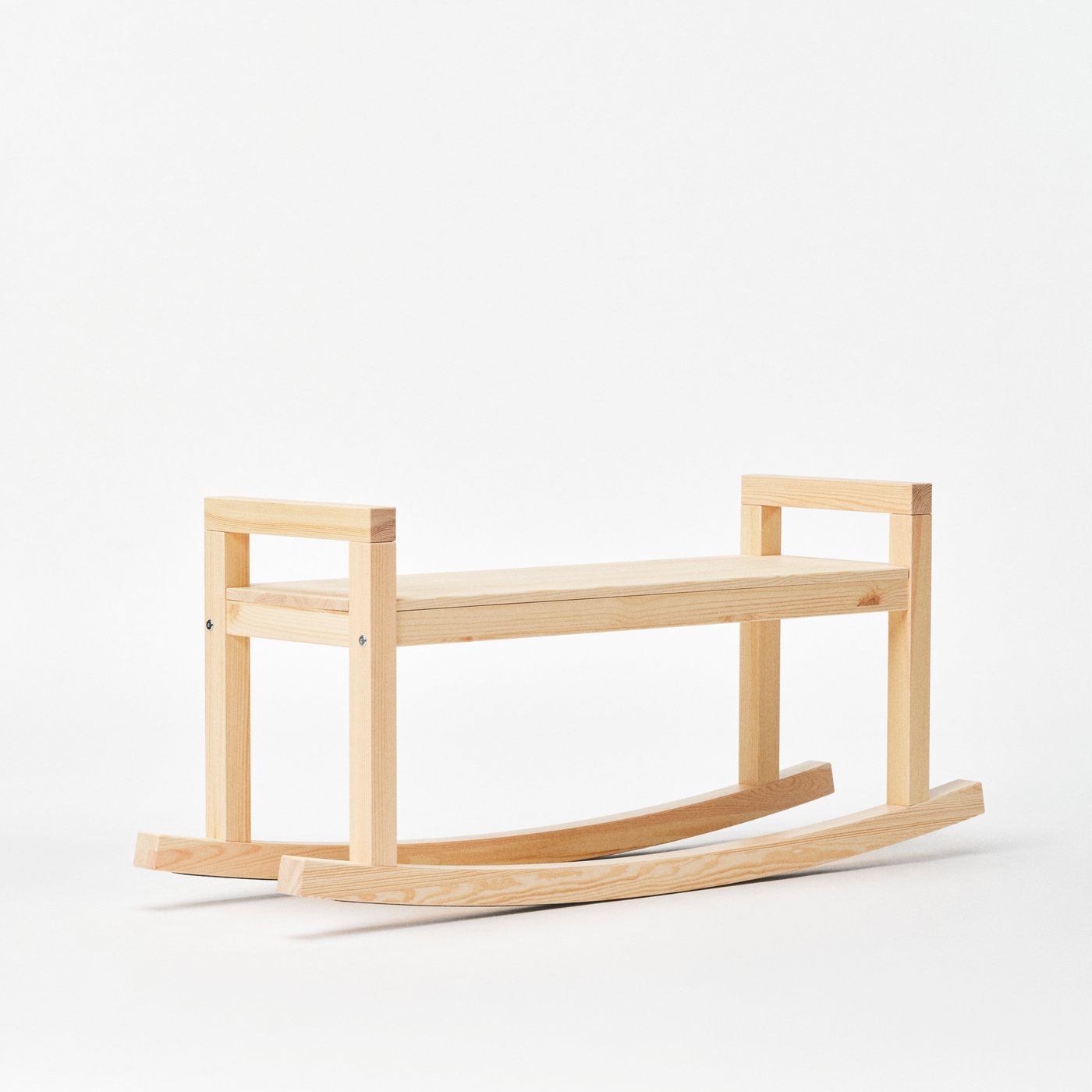 A solid pine IKEA PS 2026 rocking bench in a white studio space.