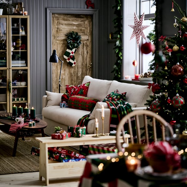 Una sala con un sofá y muebles de madera, todo decorado con colores navideños.