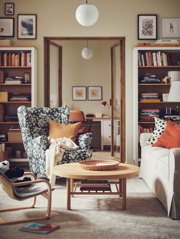 A STRANDMON wing chair and an EKTORP 3-seat sofa are in a living room with a beige base and plenty of colour accents.