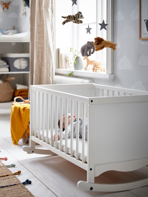 A while baby cradle in a brightly lit room.