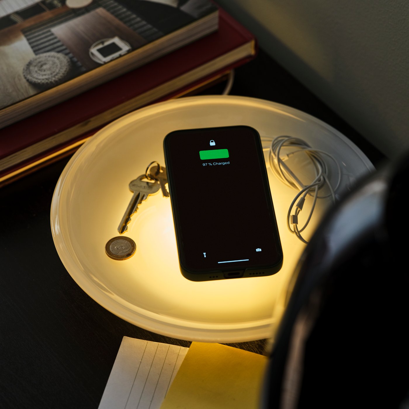 Mobilni telefon se puni na VÄSTMÄRKE bežičnom punjaču s uključenim svetlom. Ključevi se nalaze u posudi na punjaču.