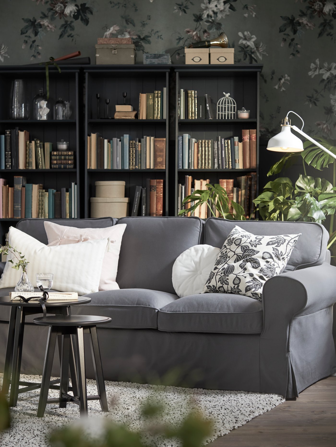 A Hallarp grey EKTORP 3-seat sofa in the living room, with a bookcase in the background