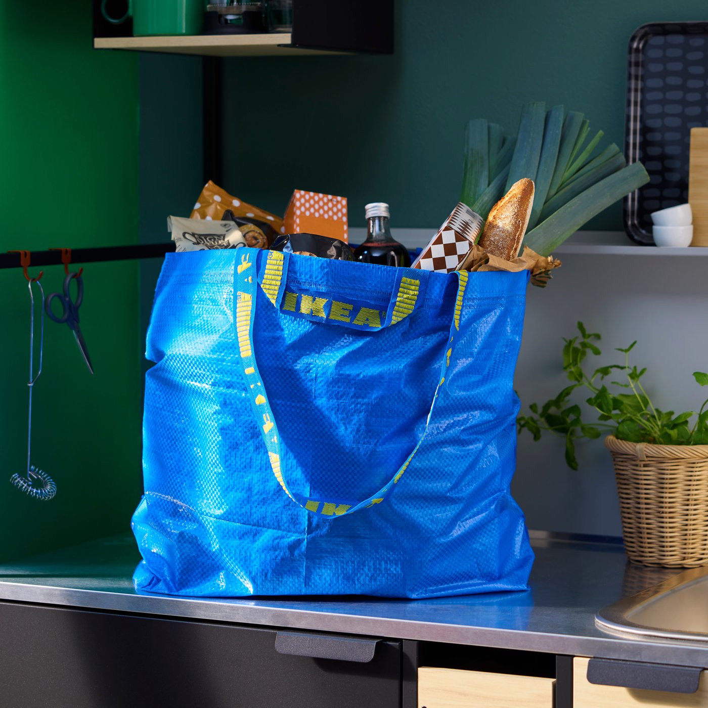 A filled FRAKTA bag sits on the counter in a kitchen.