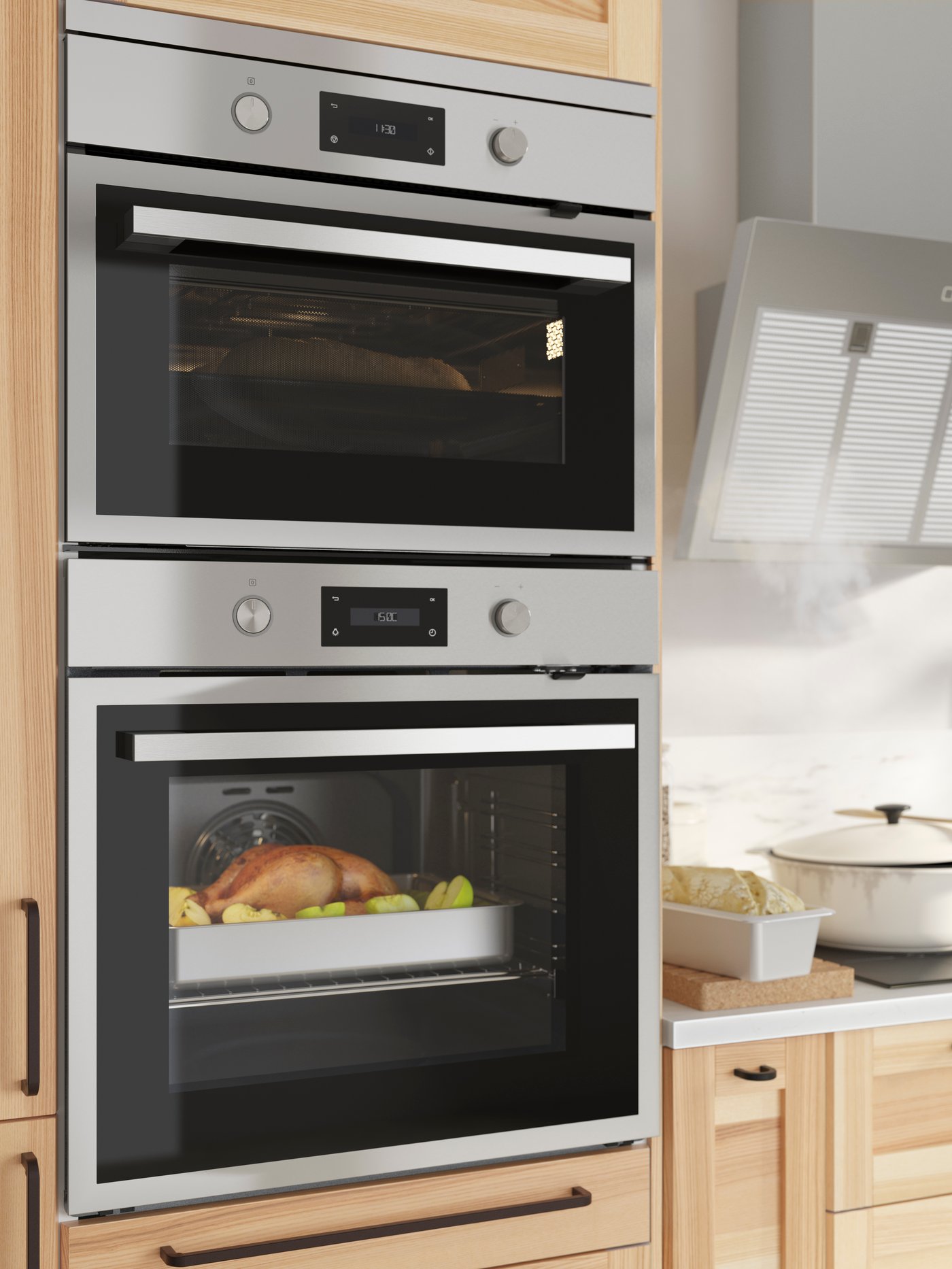 An ANRÄTTA forced-air oven with pyrolytic function in stainless steel by a wall-mounted extractor hood and kitchen items.