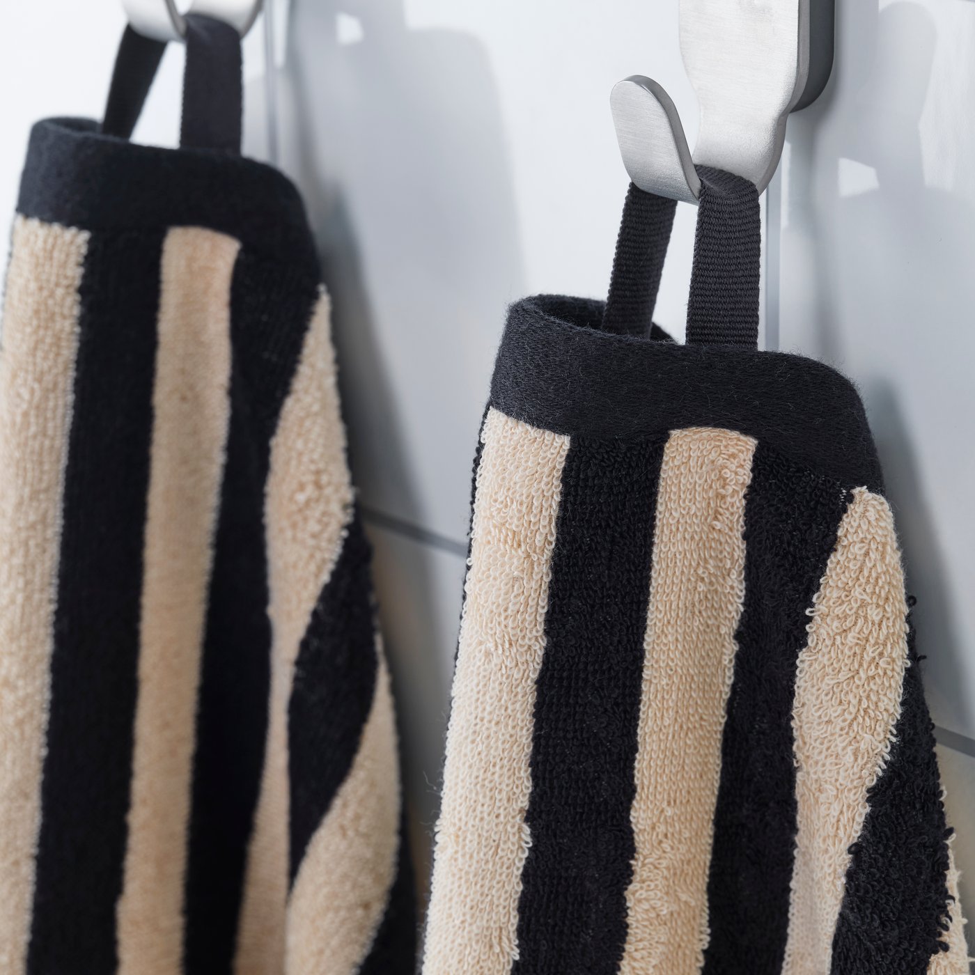 A black/light beige striped SLÅNHÖSTMAL hand towel in the bathroom