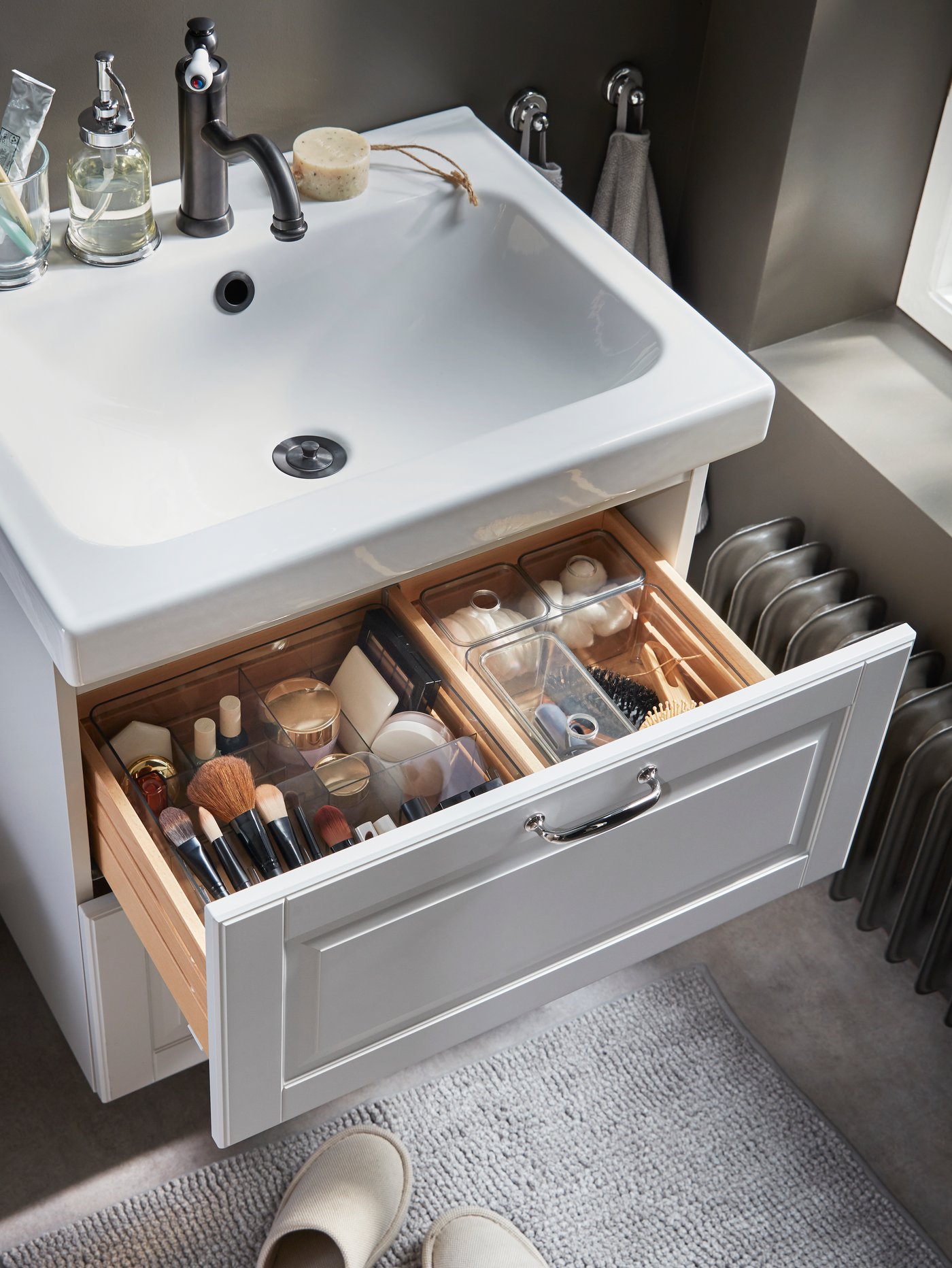 Makeup, hair and beauty tools are nicely organised in smoke-coloured see-through boxes that are in a wash-stand drawer.