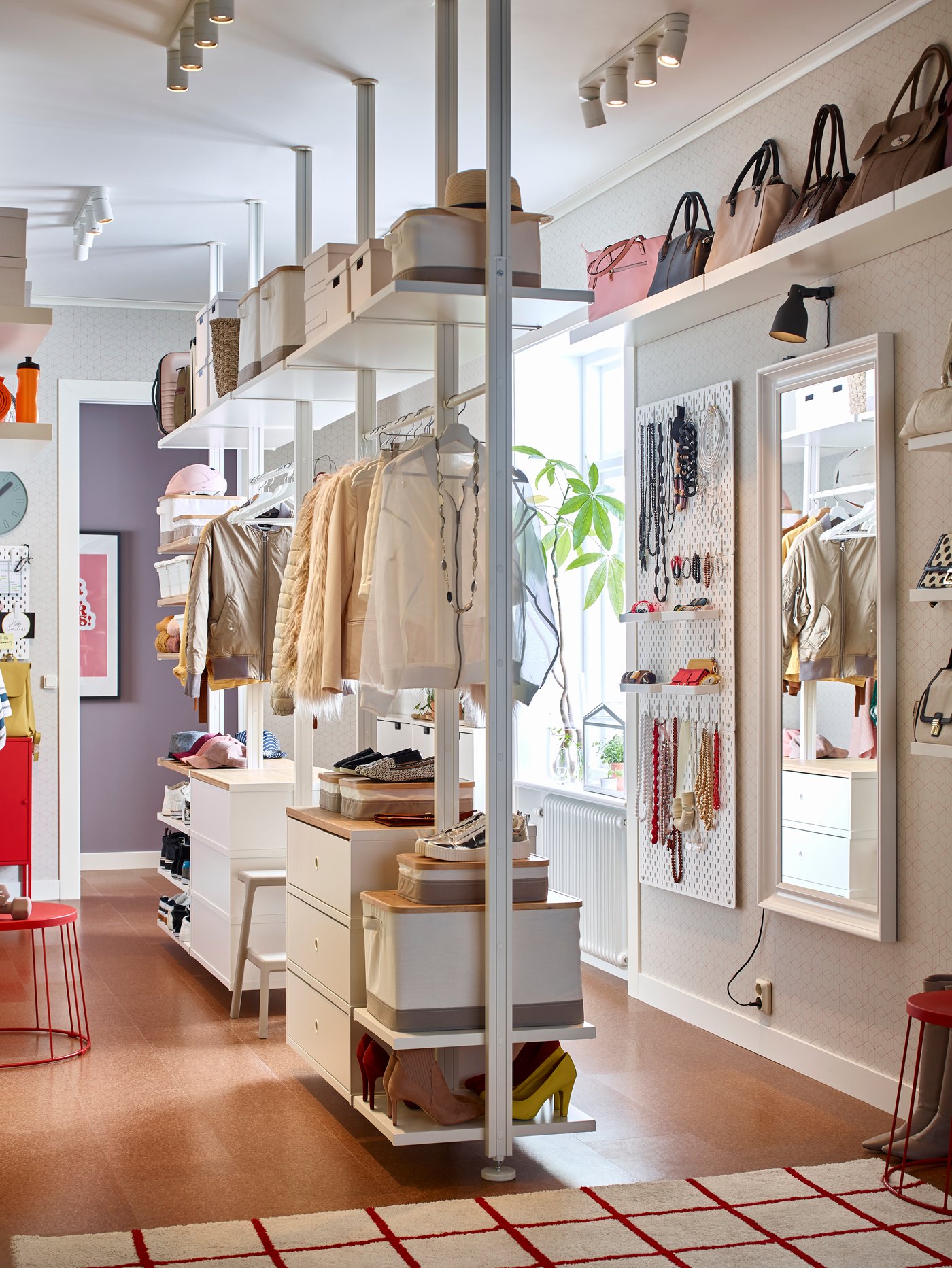 Una tienda con clósets del sistema ELVARLI de IKEA donde hay colgadas prendas y accesorios de mujer. 