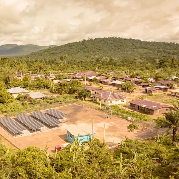 A green field with small houses and solar panels. 