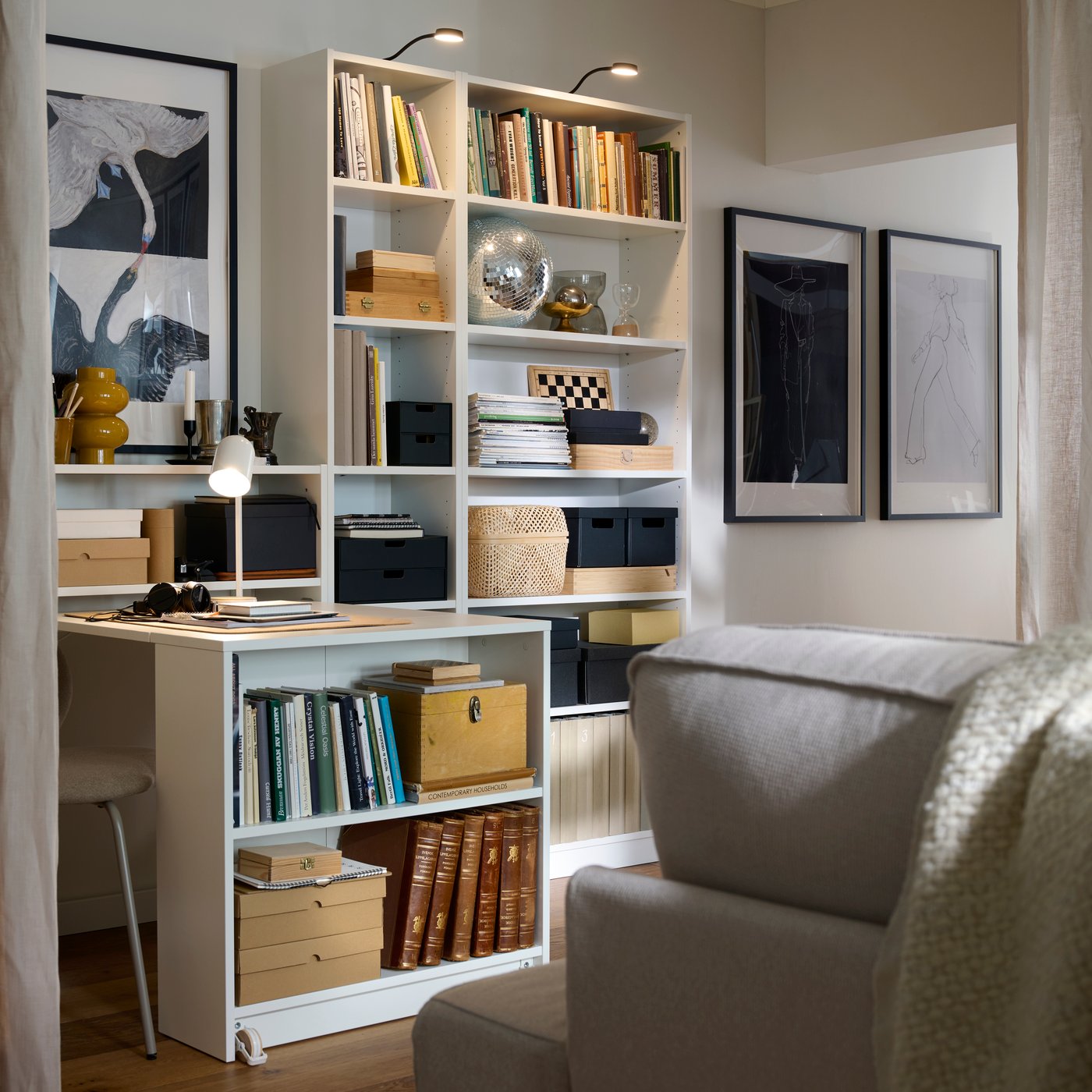 Part of a living room with a KIVIK sofa next to combo of BILLY bookcases, a section of which is pulled out to form a desk.