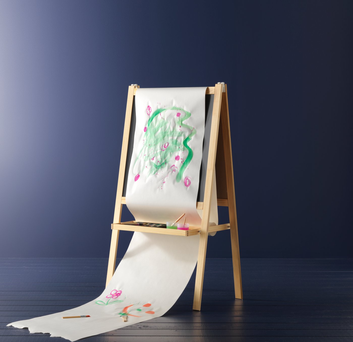 A MALA easel in a dark room. With a the MALA roll of paper covered in bright paint.