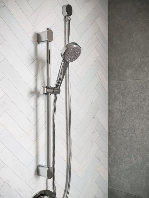 A shower wall with a BROGRUND riser rail with hand-shower kit holding a chrome plated BROGRUND thermo shower mixer.