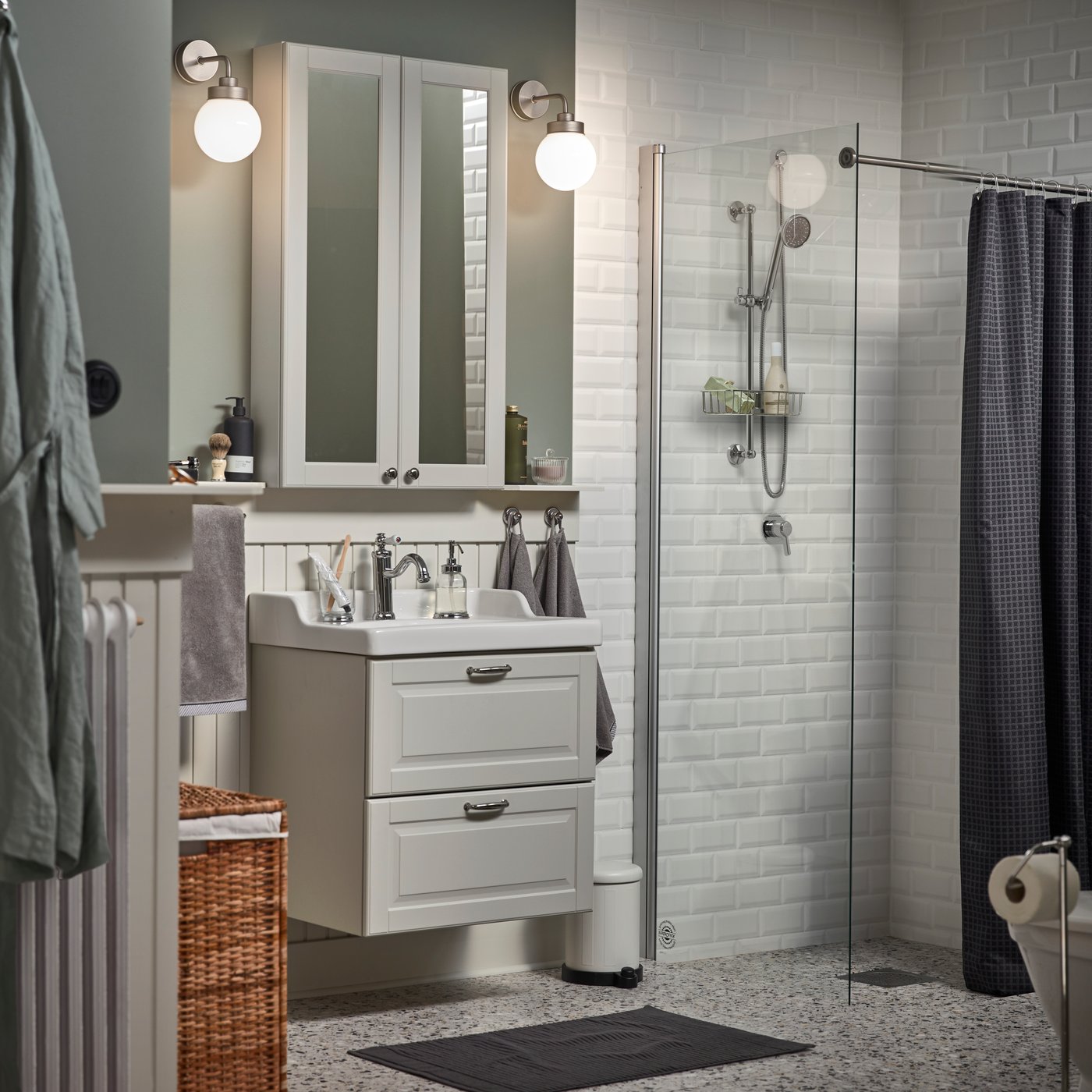 A small bathroom with a white mirror cabinet, a grey wash-stand, a dark grey bath mat and a shower curtain in anthracite.