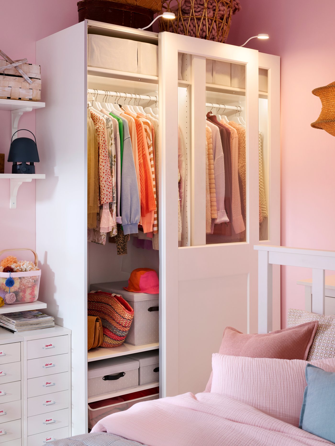 PAX wardrobe with sliding partial glass doors and light both inside and outside. One door open to show the neat order inside.
