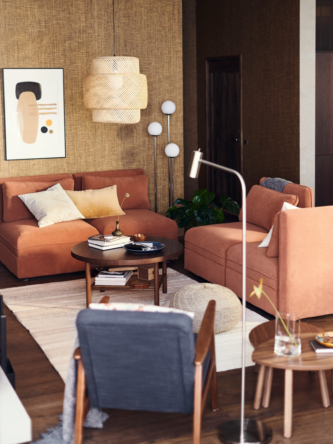Warm modern living room with terracotta sofas, woven pendant lamp, wooden coffee table, and cozy Scandinavian-inspired décor.