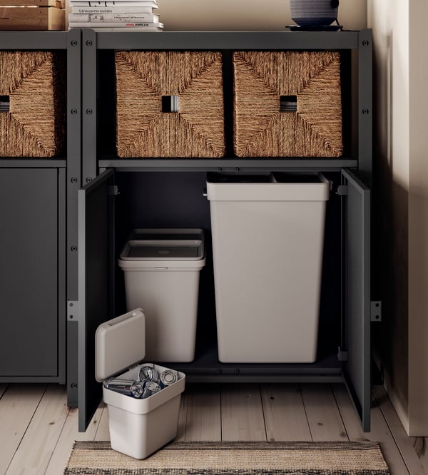 A BROR cabinet with doors. The doors are open and displaying HÅLLBAR bins with lids inside.