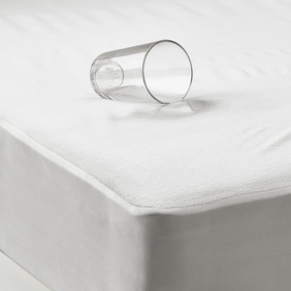 un protège-matelas GRUSNARV étanche avec un verre renversé dessus