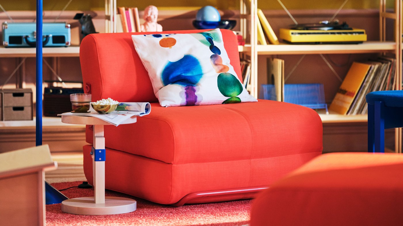 A jasně oranžová rozkládací židle Skiftebo IKEA PS 2026 v obývacím pokoji