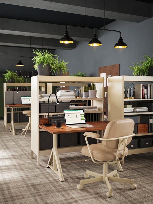 A brown/beige IDÅSEN desk and beige leather chair with a built-in shelf and room divider shown next to several desks.
