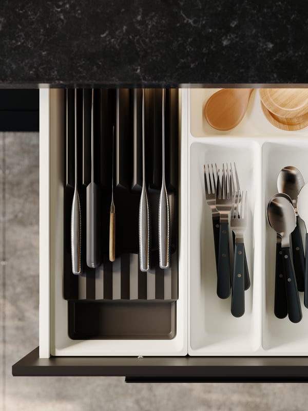 Cutlery and coasters are neatly placed in a white UPPDATERA tray and kitchen knives in an anthracite-coloured knife rack.