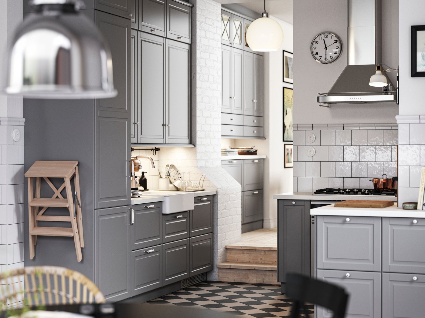 A traditional kitchen with a chequered floor, grey BODBYN kitchen fronts and white/light grey stone effect/laminate worktops.