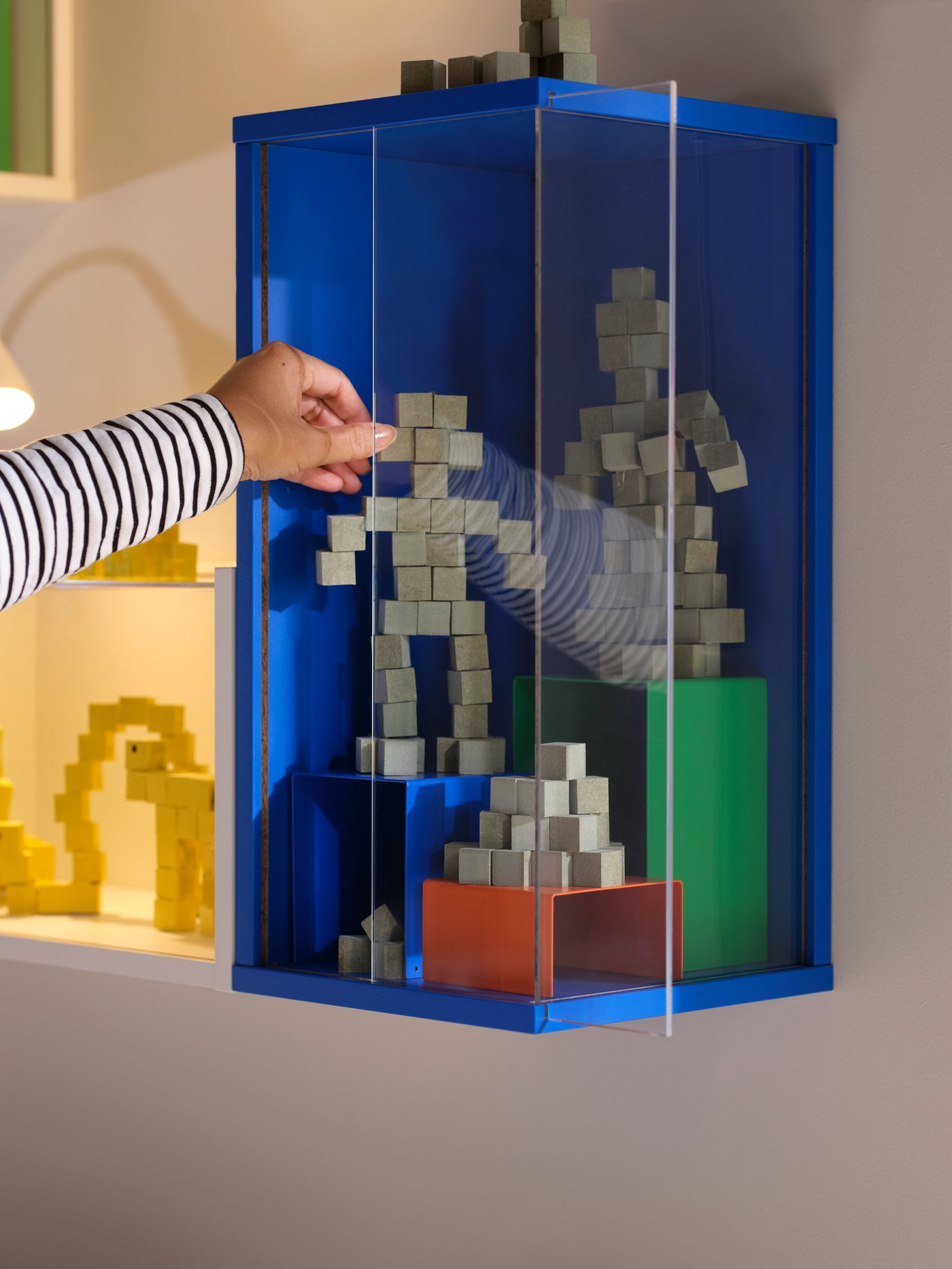A bright blue BRÄNNBOLL wall-mounted display cabinet