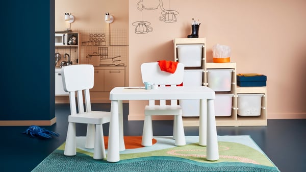 Two white MAMMUT children's chairs and white MAMMUT table in the children's room.