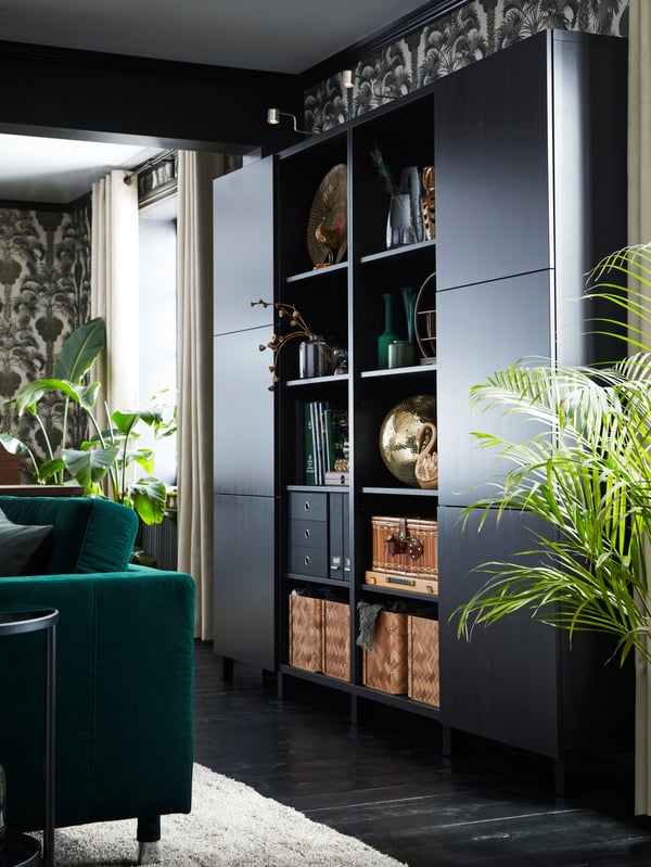 A black-brown BESTÅ storage combination with two columns of closed storage and two of open storage holding baskets and boxes.
